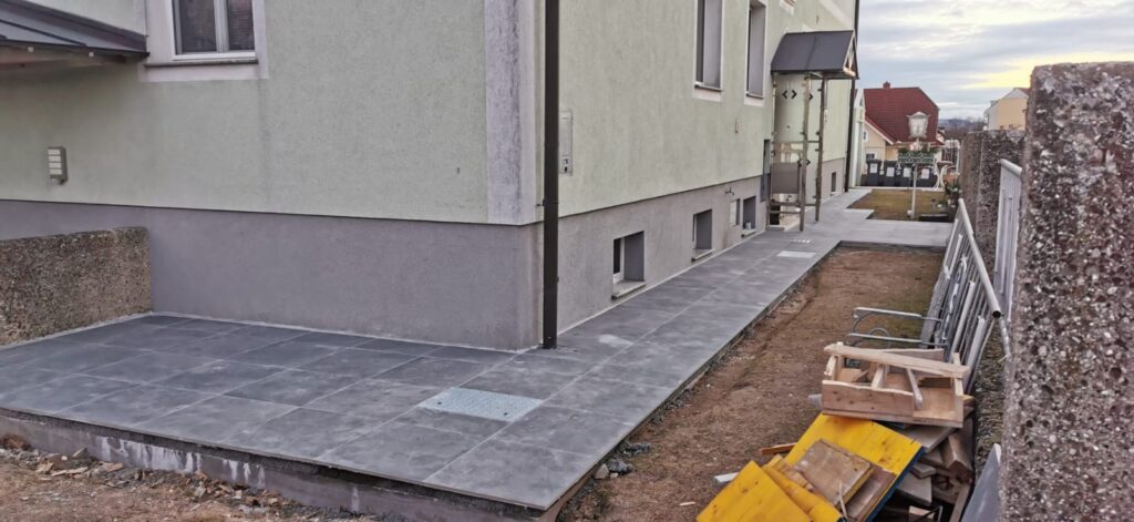 Verlegte Terrassenfliesen mit sauberem Übergang zur Hauswand in Wien